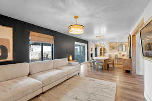 Living room featuring light wood-type flooring and a chandelier