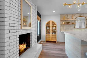 Dining area featuring a fireplace, a notable chandelier, and light wood-type flooring