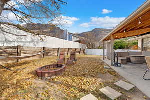 View of yard with a patio area, a mountain view, and an outdoor living space with a fire pit