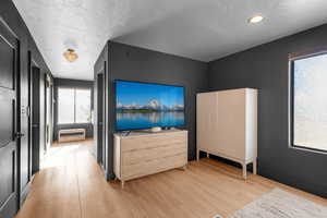 Bedroom with a textured ceiling and light hardwood / wood-style flooring