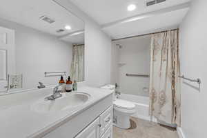 Full bathroom featuring tile patterned floors, vanity, shower / bath combo, and toilet