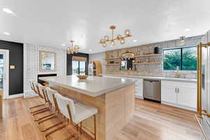 Kitchen featuring a center island, stainless steel appliances, white cabinetry, and a wealth of natural light