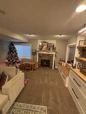 Living room featuring dark colored carpet and a fireplace