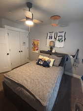 Carpeted bedroom featuring ceiling fan and a closet