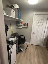 Washroom featuring wood-type flooring and a textured ceiling