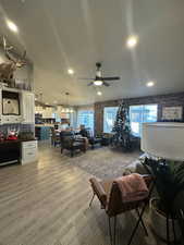 Living room featuring hardwood / wood-style flooring and ceiling fan with notable chandelier