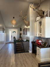 Kitchen featuring white cabinetry, lofted ceiling, and light wood-type flooring