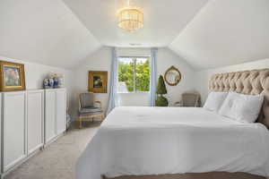 Carpeted bedroom featuring lofted ceiling