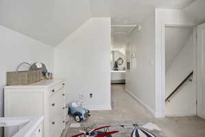 Carpeted bedroom featuring a textured ceiling and vaulted ceiling