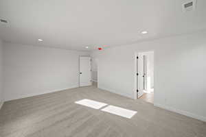 Primary Suite. Unfurnished room with light colored carpet
