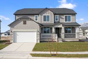 Craftsman-style house featuring a front yard, a porch, and a garage