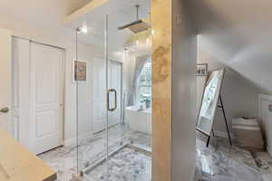 Bathroom featuring plus walk in shower and lofted ceiling