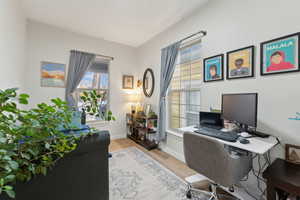 Office space with light hardwood / wood-style flooring