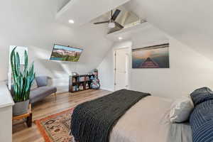 Bedroom with ceiling fan, light hardwood / wood-style flooring, and lofted ceiling