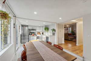 Dining space featuring light wood-type flooring, sink, and an inviting chandelier