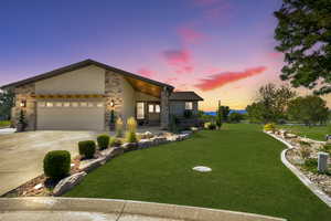 View of front of property featuring a yard and a garage