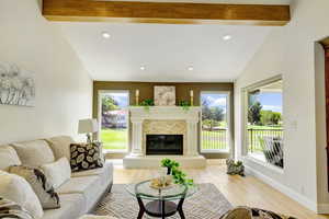 Living room featuring beam ceiling, light hardwood / wood-style floors, and high vaulted ceiling