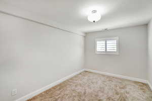 Unfurnished room with light colored carpet