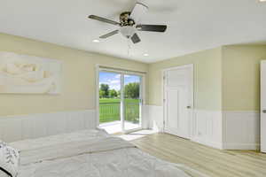 Unfurnished bedroom with ceiling fan, access to exterior, and light hardwood / wood-style flooring