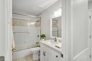 Full bathroom featuring vanity, enclosed tub / shower combo, and toilet