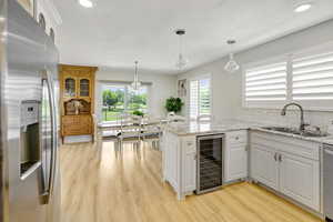 Kitchen with sink, kitchen peninsula, plenty of natural light, white cabinets, and appliances with stainless steel finishes