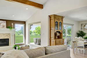 Living room with light hardwood / wood-style flooring and lofted ceiling with beams