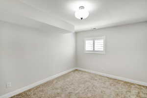 Unfurnished room featuring light carpet