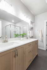 Bathroom featuring tile patterned flooring, an enclosed shower, and vanity