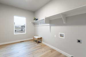 Laundry room with hookup for a washing machine, light hardwood / wood-style floors, and hookup for an electric dryer