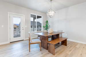 Dining area with an inviting chandelier and light hardwood / wood-style floors