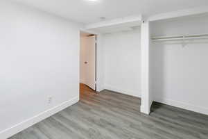 Unfurnished bedroom featuring wood-type flooring and a closet