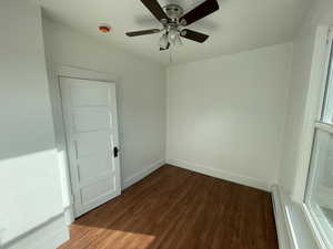 Unfurnished room with hardwood / wood-style floors, baseboard heating, and ceiling fan