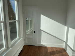 Doorway to outside with a healthy amount of sunlight and dark hardwood / wood-style floors