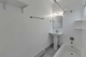 Bathroom with shower / bath combination and a baseboard heating unit