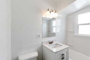 Full bathroom with vanity, toilet, and shower / tub combination