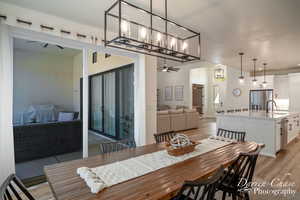 Dining area featuring ceiling fan, sink, and light wood-type flooring