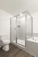 Bathroom with hardwood / wood-style floors, toilet, and an enclosed shower