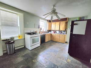 Kitchen with ceiling fan, sink, dishwasher, white range with gas stovetop, and a baseboard heating unit