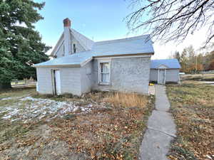 View of side of home with a storage unit