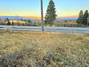 Yard at dusk featuring a mountain view and a rural view