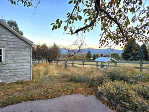 Yard at dusk with a mountain view and a rural view