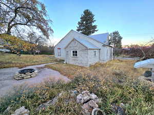 View of side of property with an outdoor fire pit