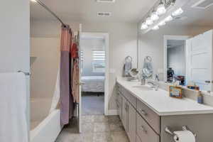 Bathroom featuring tile patterned floors, vanity, and shower / tub combo