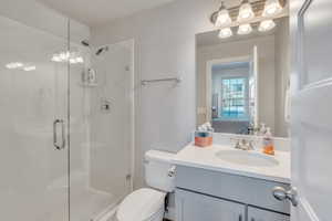 Bathroom featuring vanity, toilet, and an enclosed shower