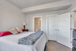 Carpeted bedroom featuring ensuite bathroom