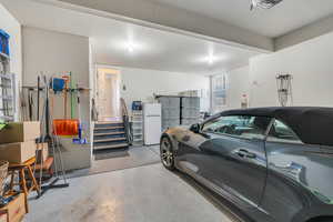 Garage featuring white refrigerator