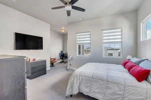 Carpeted bedroom featuring ceiling fan