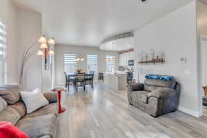 Living room featuring a notable chandelier, light hardwood / wood-style floors, and sink