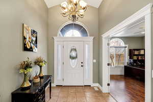 Foyer featuring a chandelier, lofted ceiling, and hardwood / wood-style flooring