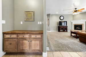 Carpeted living room with a tile fireplace and ceiling fan